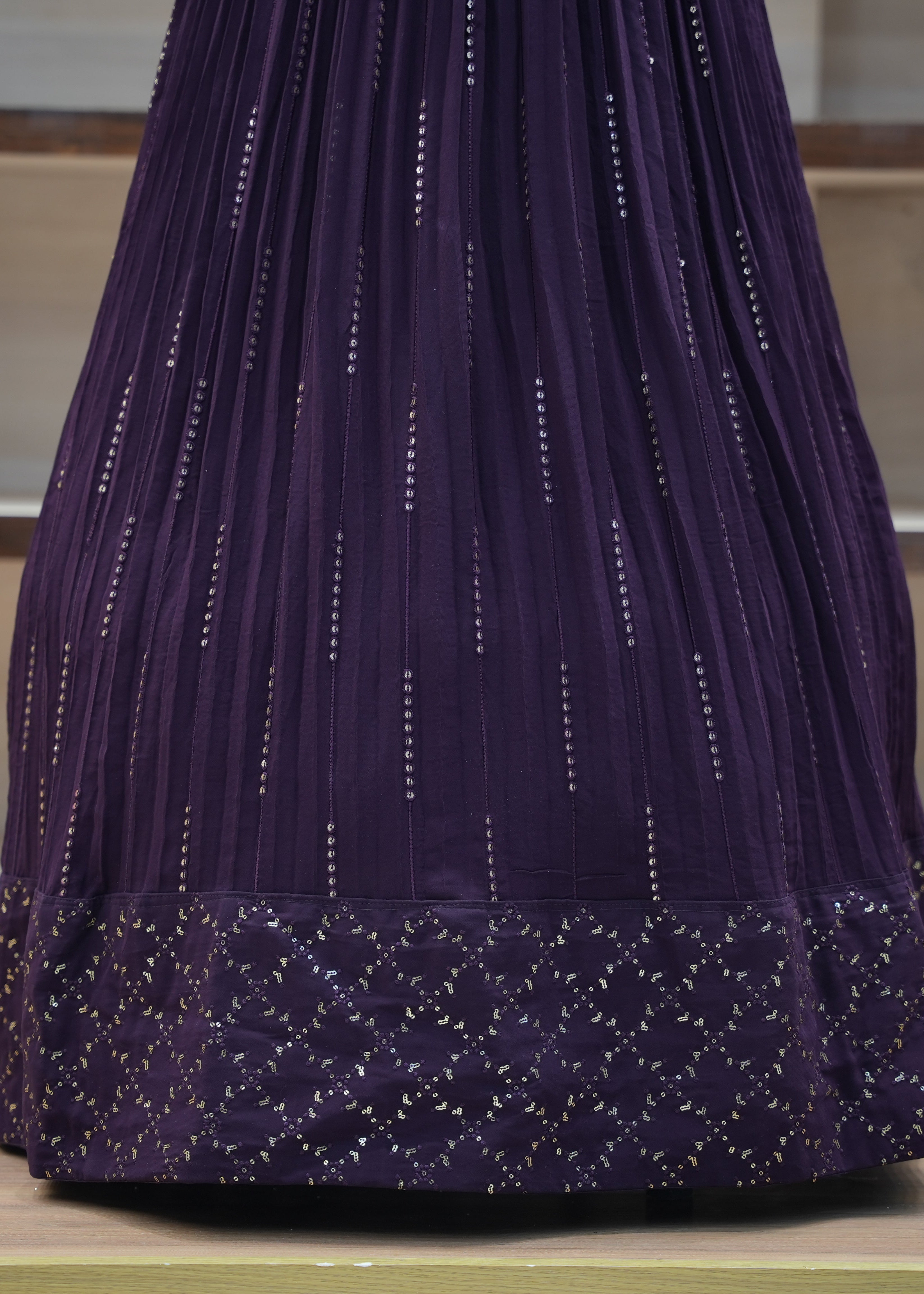 Purple embroidered garment on a wooden surface with a neutral background