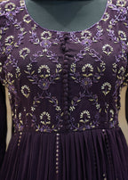 Purple dress with floral embroidery on a plain background