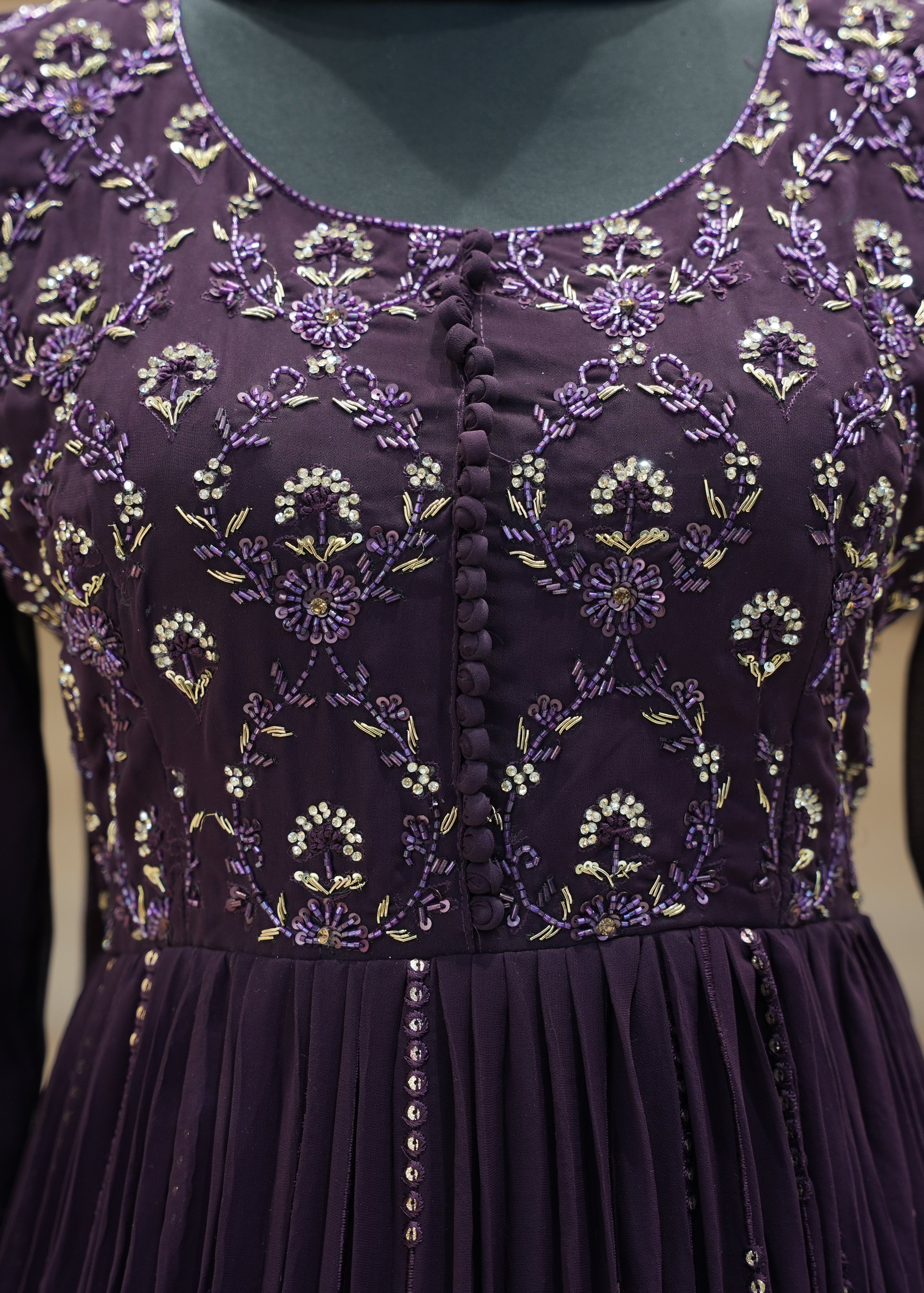 Purple dress with floral embroidery on a plain background