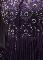 Close-up of a purple dress with intricate floral embroidery and sequin details.