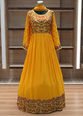 Yellow dress with floral patterns on a mannequin against a wooden panel background