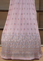 Pink embroidered traditional garment on a wooden surface