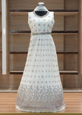 White floral dress on a mannequin against a wooden shelf background