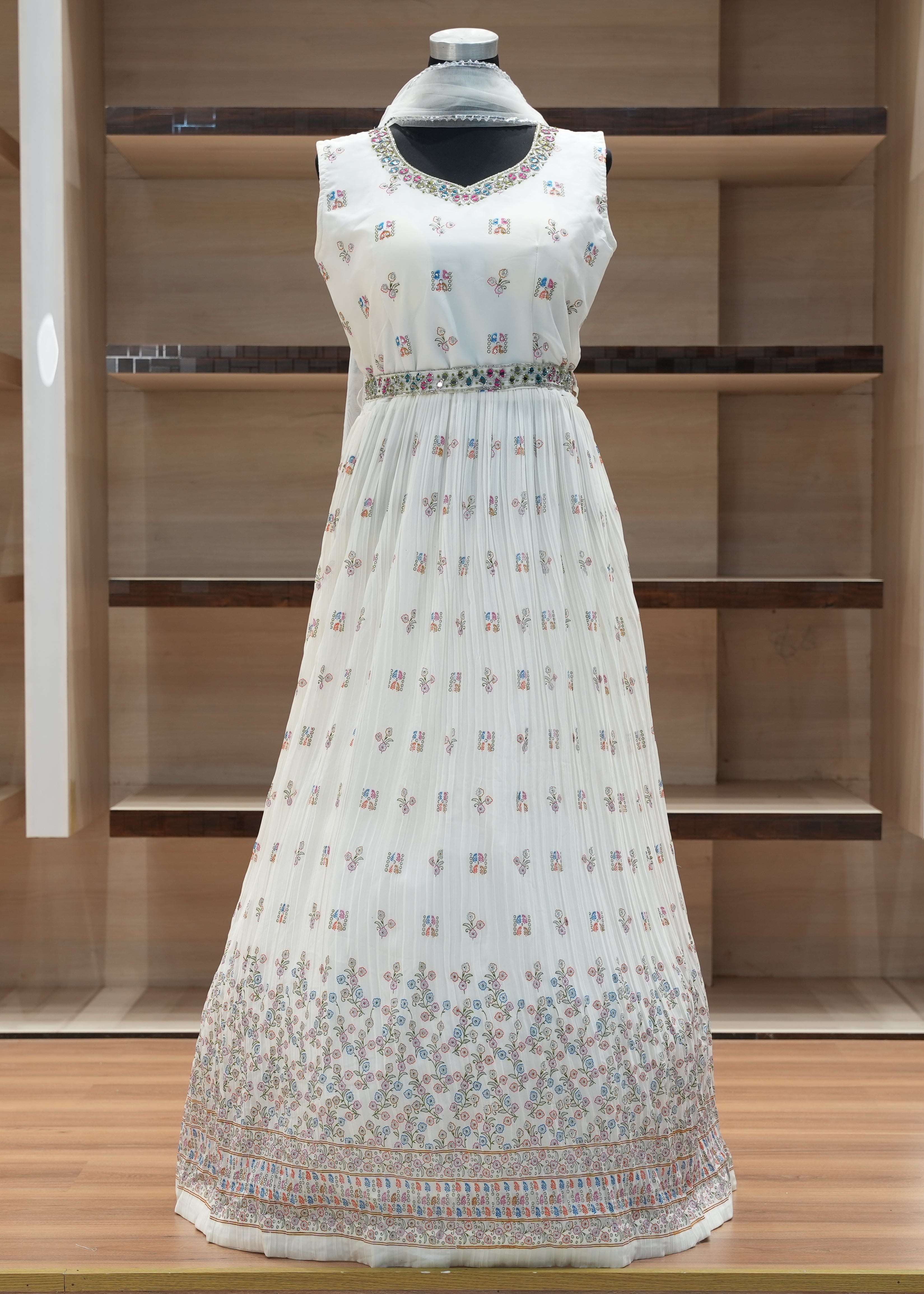 White floral dress on a mannequin against a wooden shelf background