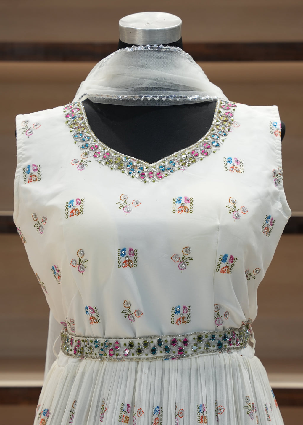 White embroidered dress on a mannequin with a blurred background