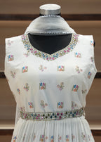 White embroidered dress on a mannequin with a blurred background