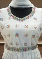 White blouse with floral embroidery and embellishments on a plain background