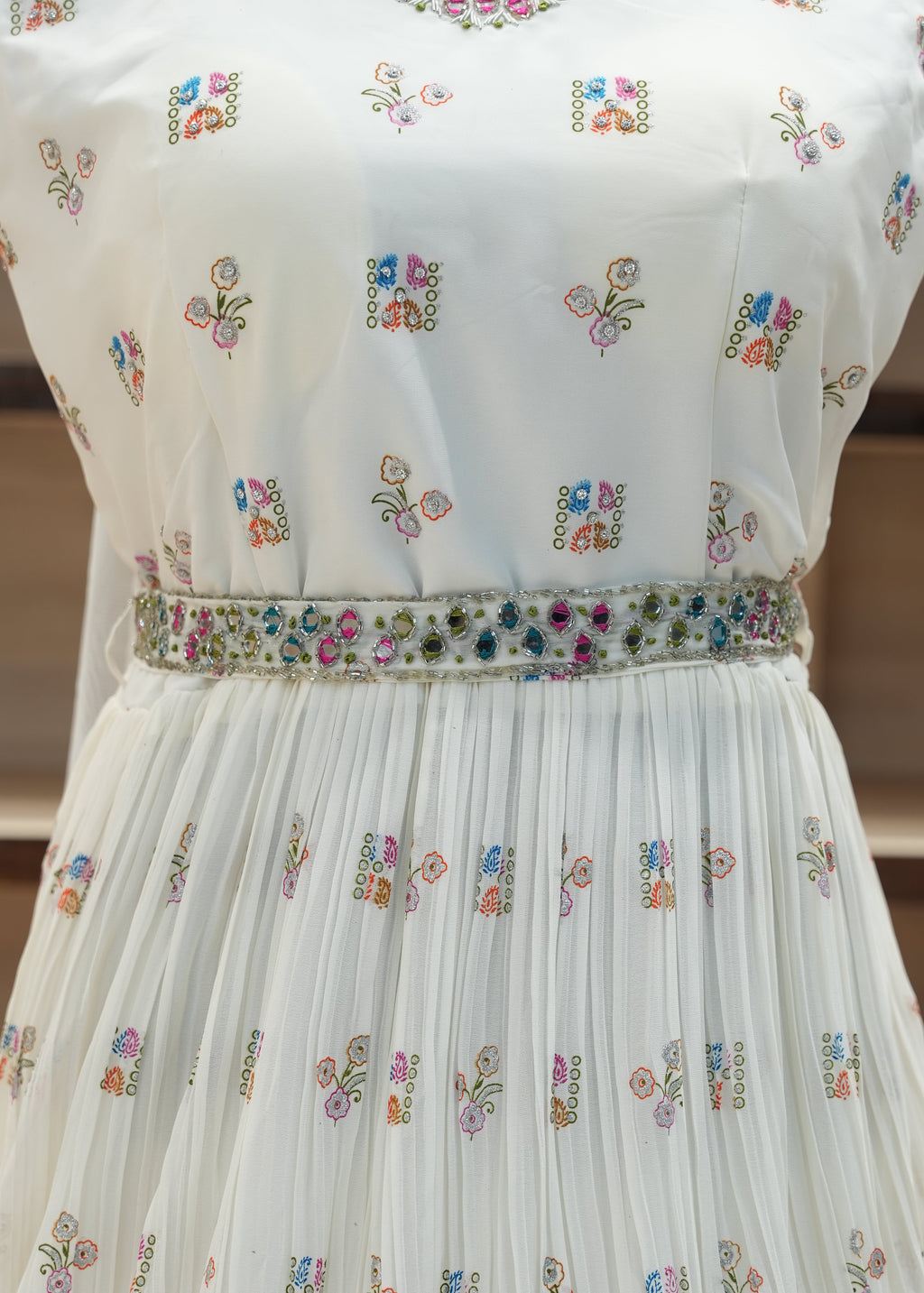 White pleated fabric with floral embroidery on a blurred background