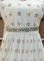 White pleated fabric with floral embroidery on a blurred background