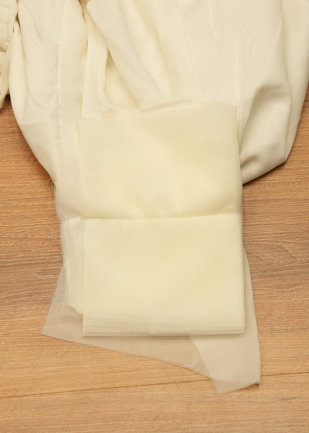 White fabric with floral embroidery on a wooden surface