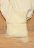 White fabric with floral embroidery on a wooden surface