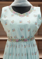 Light blue dress with intricate embroidery on a wooden shelf background