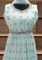 Light blue dress with colorful floral patterns on a wooden mannequin.