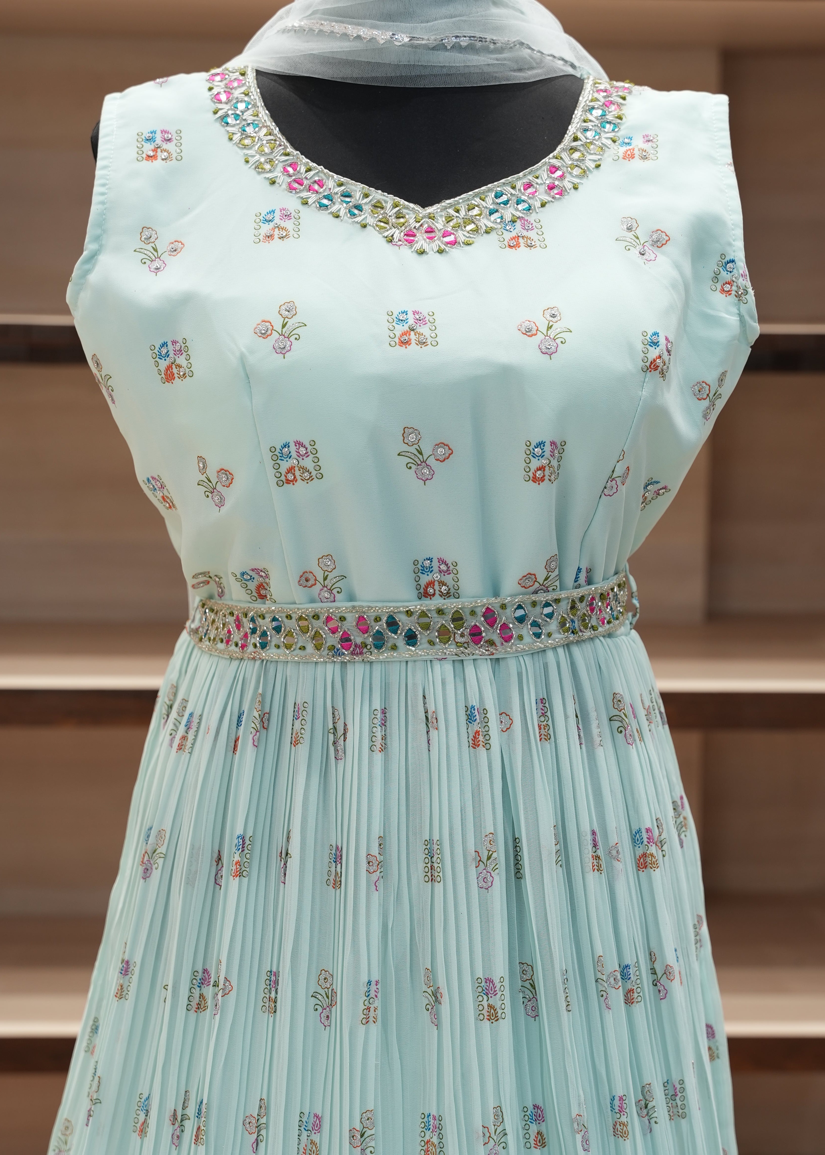 Light blue dress with colorful floral patterns on a wooden mannequin.