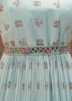 Light blue dress with floral embroidery on a wooden background
