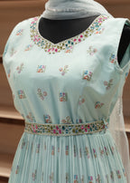 Light blue embroidered blouse with floral patterns on a plain background