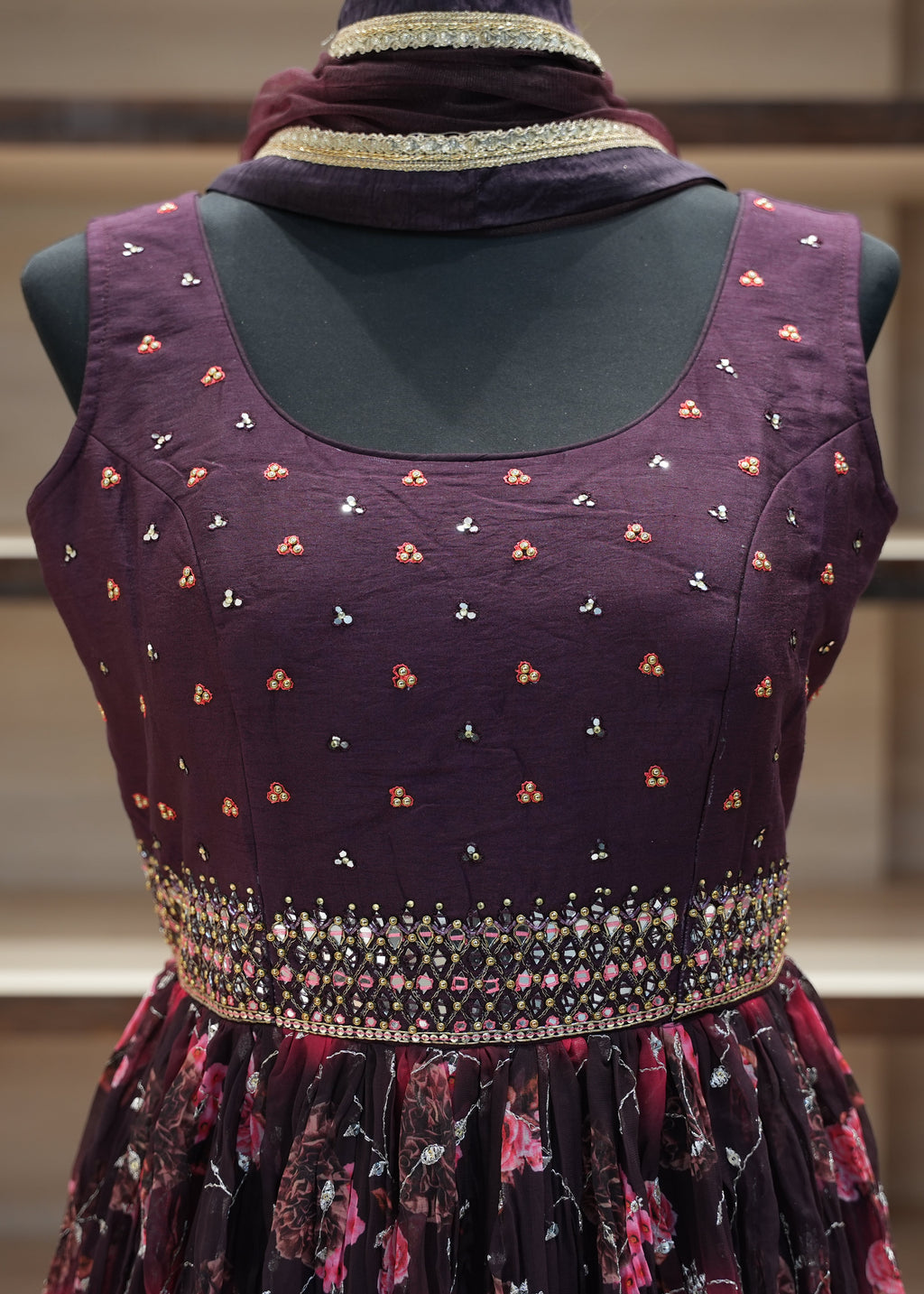Purple dress with floral patterns on a mannequin against a neutral background