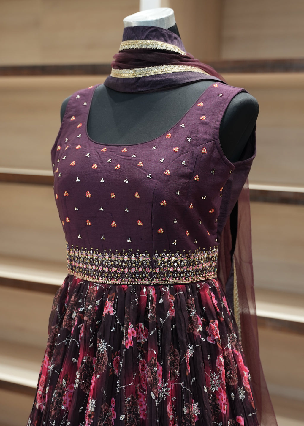 Purple traditional outfit with floral patterns on a mannequin against a neutral background