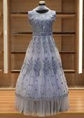 Elegant silver evening gown on a mannequin against a wooden panel background