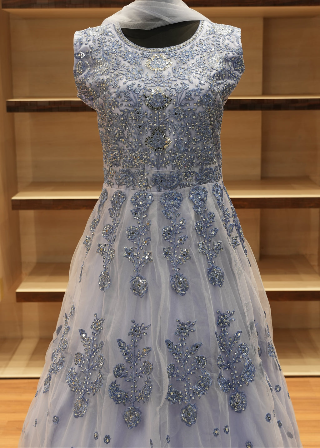 Silver beaded evening gown on a wooden rack