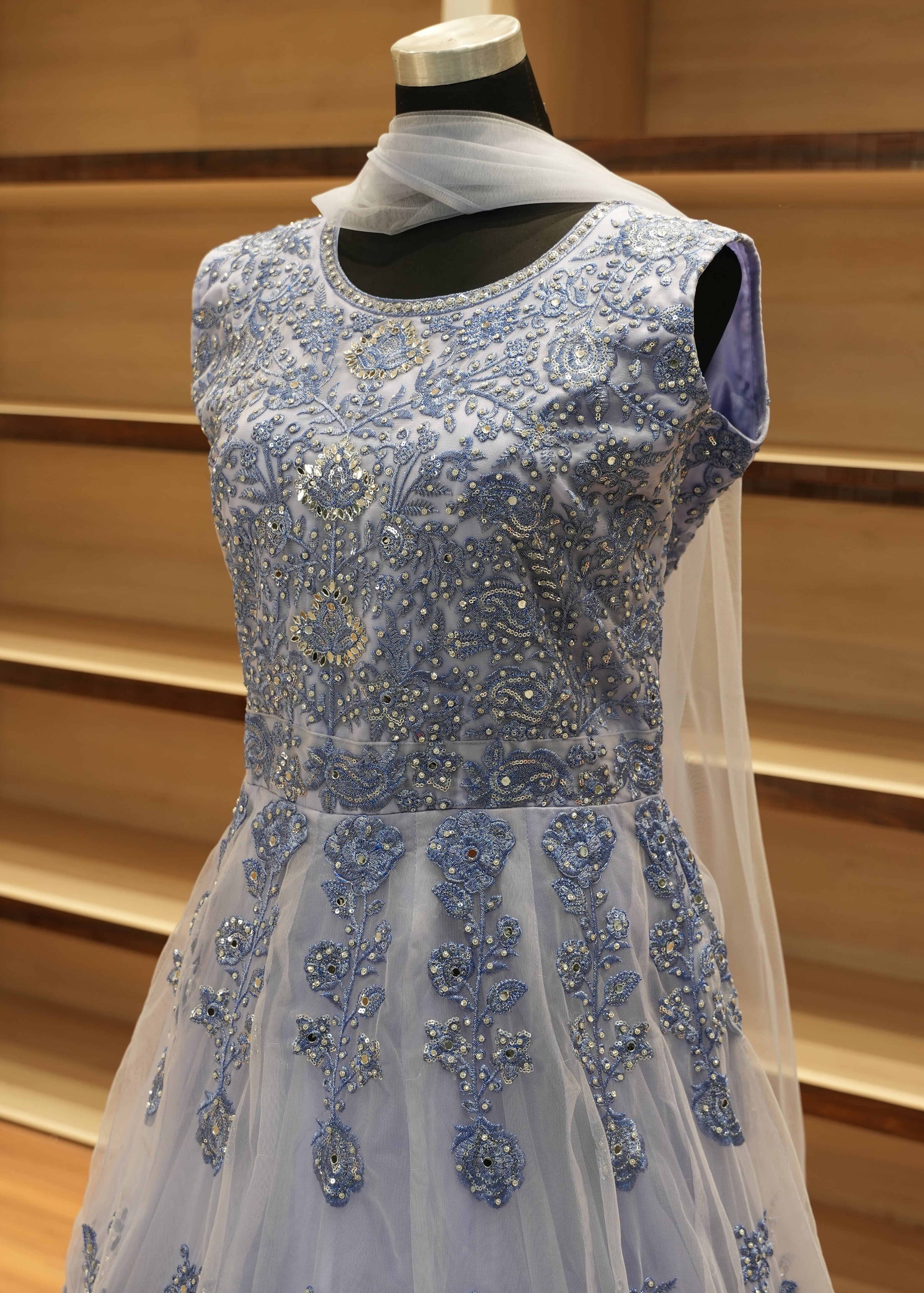 Blue beaded evening gown on a wooden rack
