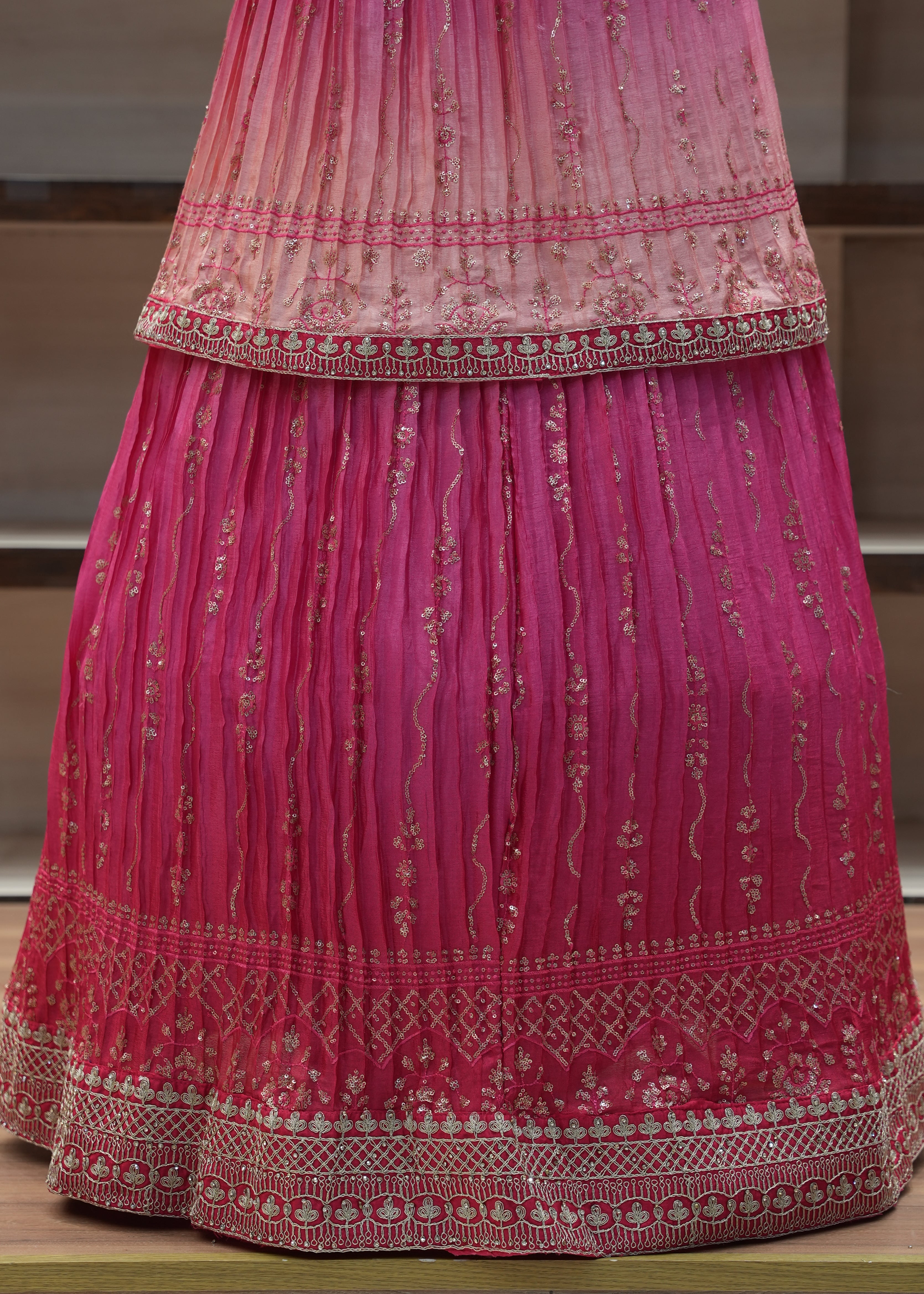 Pink saree with intricate patterns on a wooden surface