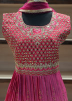 Pink embroidered dress on a mannequin with a blurred background
