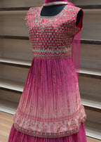 Pink dress with intricate detailing on a mannequin against a neutral background