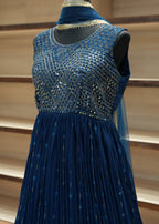 Close-up of a blue dress with intricate detailing on a neutral background