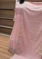 Pink textured fabric draped over a chair with a wooden background