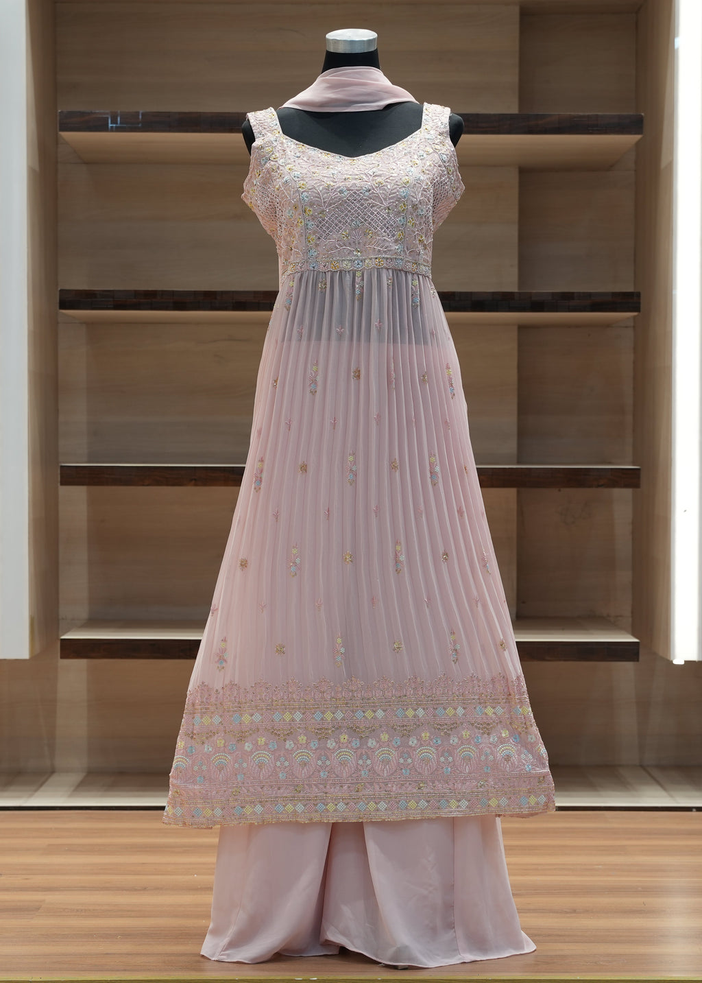 Light pink traditional outfit on a mannequin against a wooden background