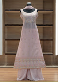 Light pink traditional outfit on a mannequin against a wooden background