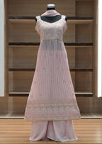 Light pink traditional outfit on a mannequin against a wooden background