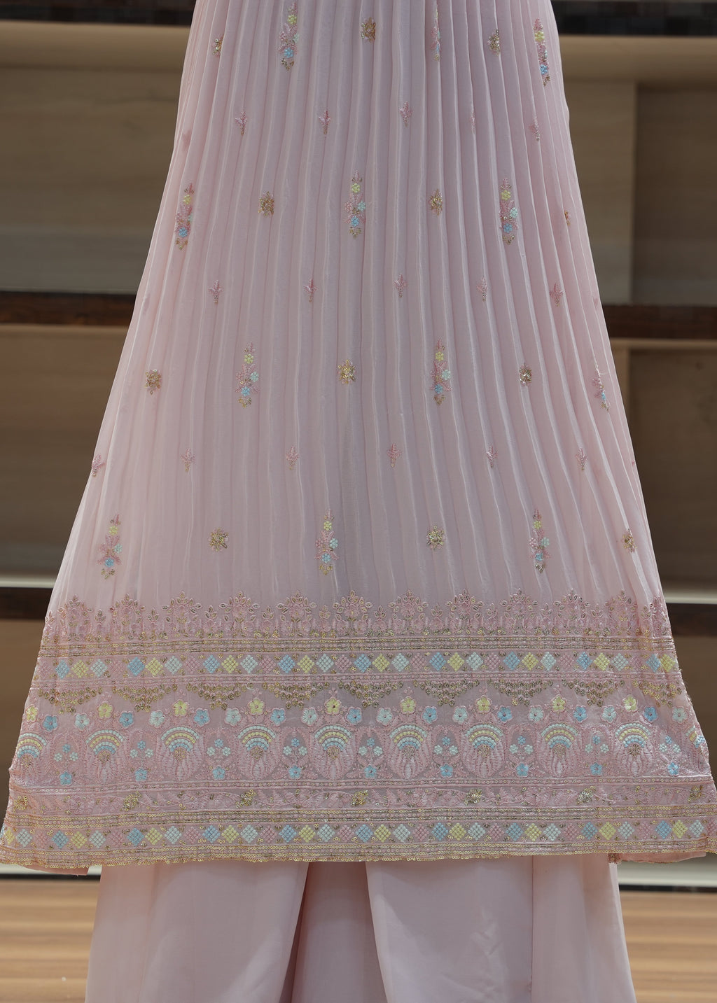 Pink embroidered fabric draped over a surface with a neutral background