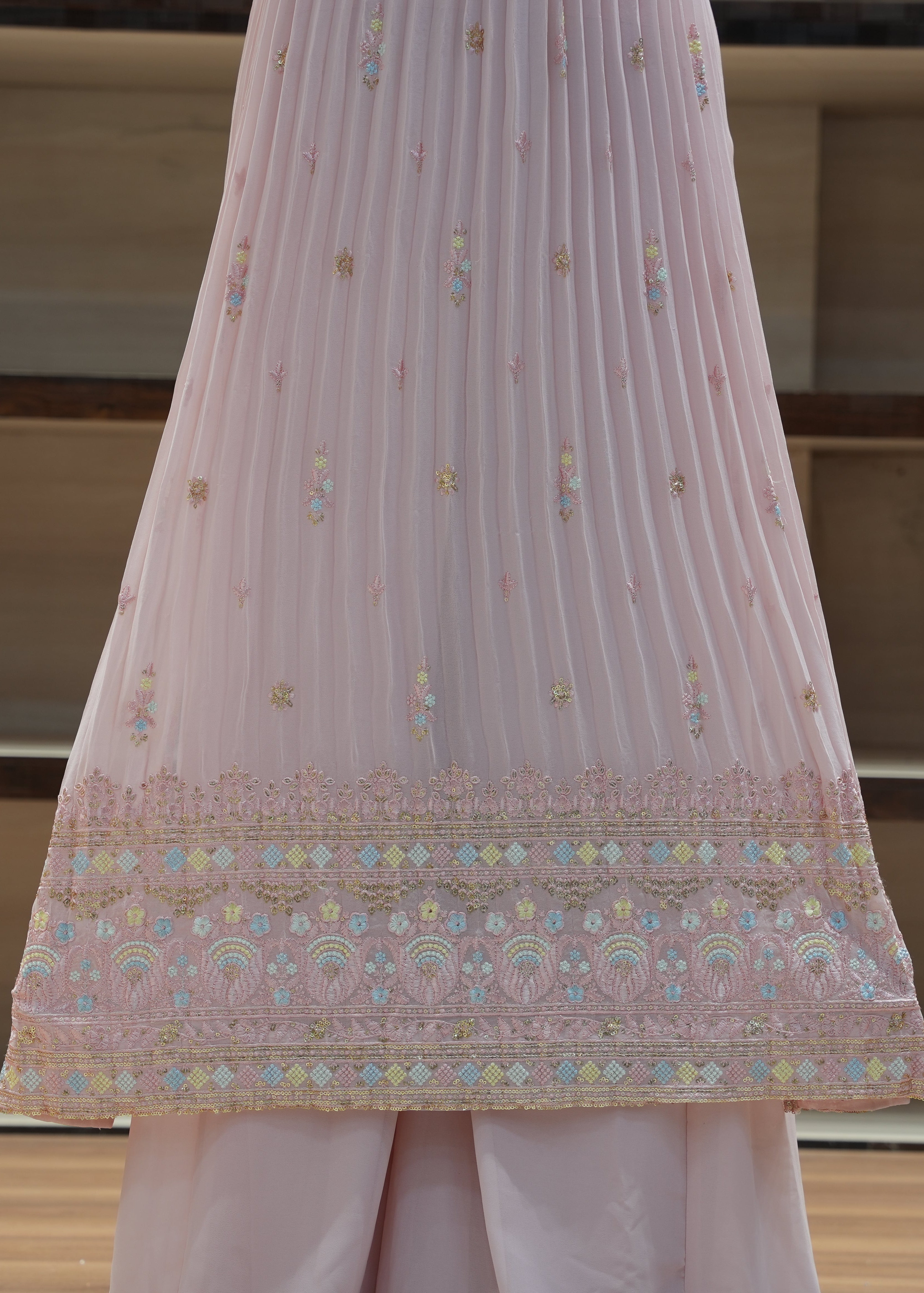 Pink embroidered fabric draped over a surface with a neutral background