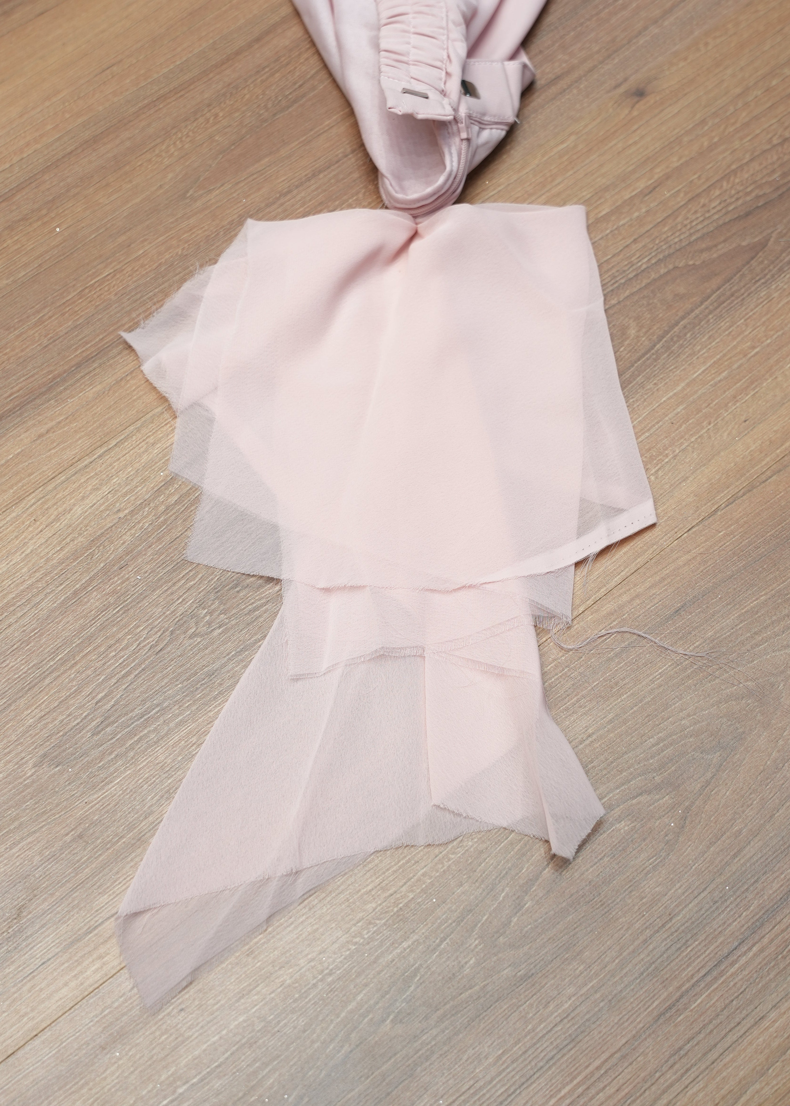 Pink fabric bow on a wooden surface
