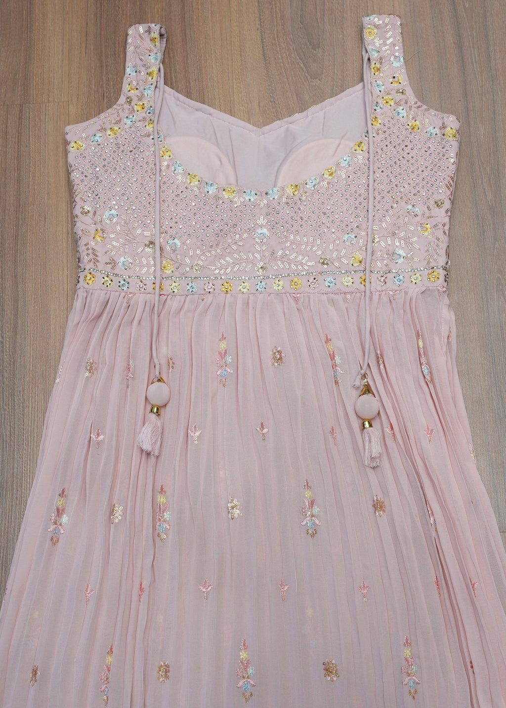 Pink embroidered dress on a wooden floor