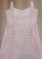 Pink embroidered dress on a wooden floor