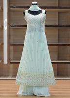 Light blue dress with floral pattern on a mannequin against a wooden background