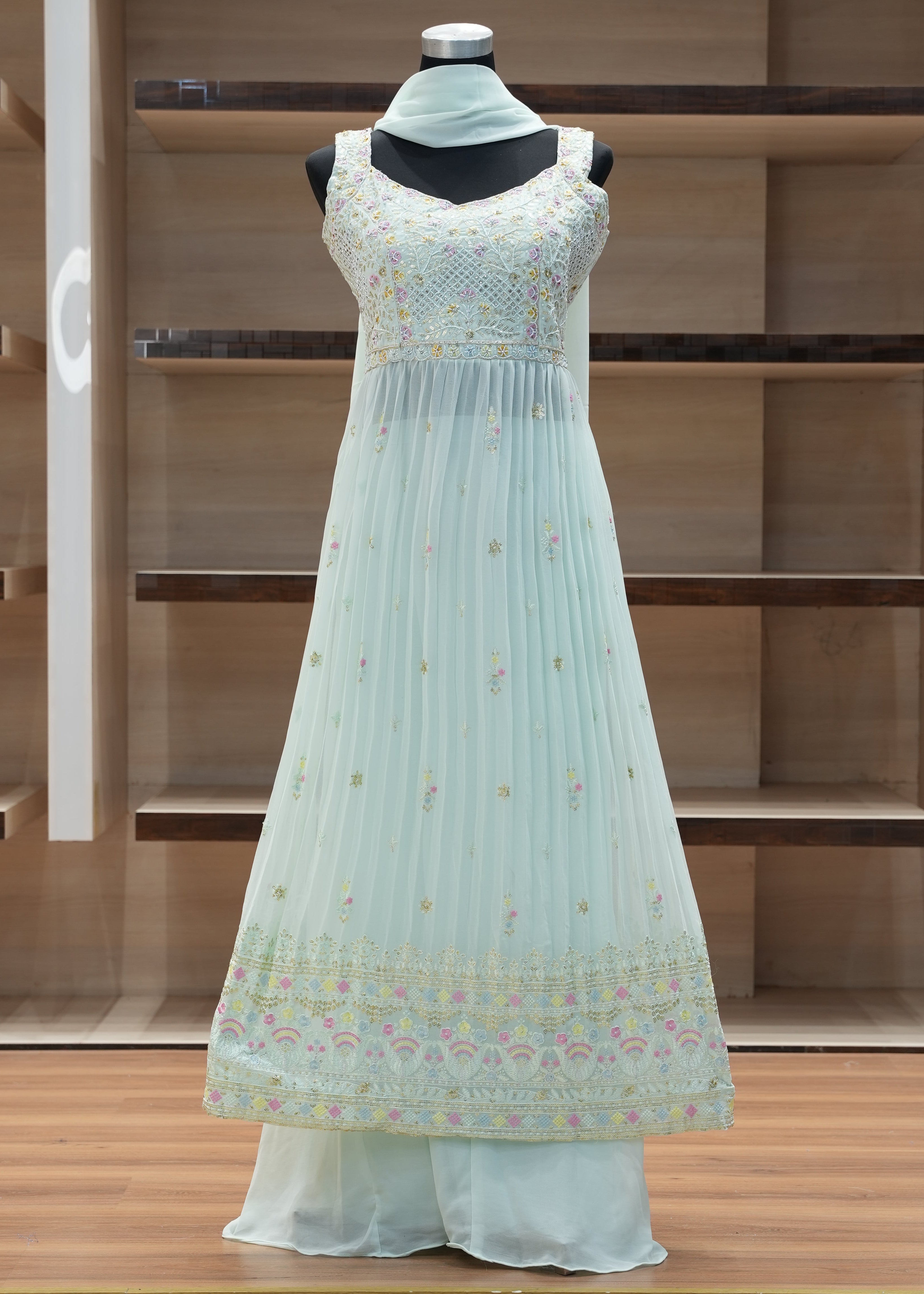 Light blue dress with floral pattern on a mannequin against a wooden background