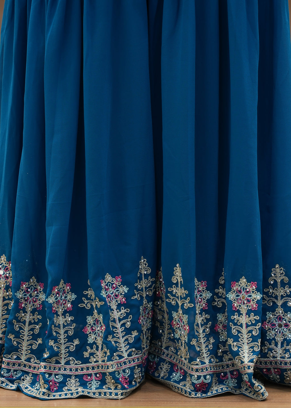 Blue dress with intricate white embroidery on a wooden surface