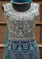 Decorative garment with intricate patterns and embellishments on a wooden stand.