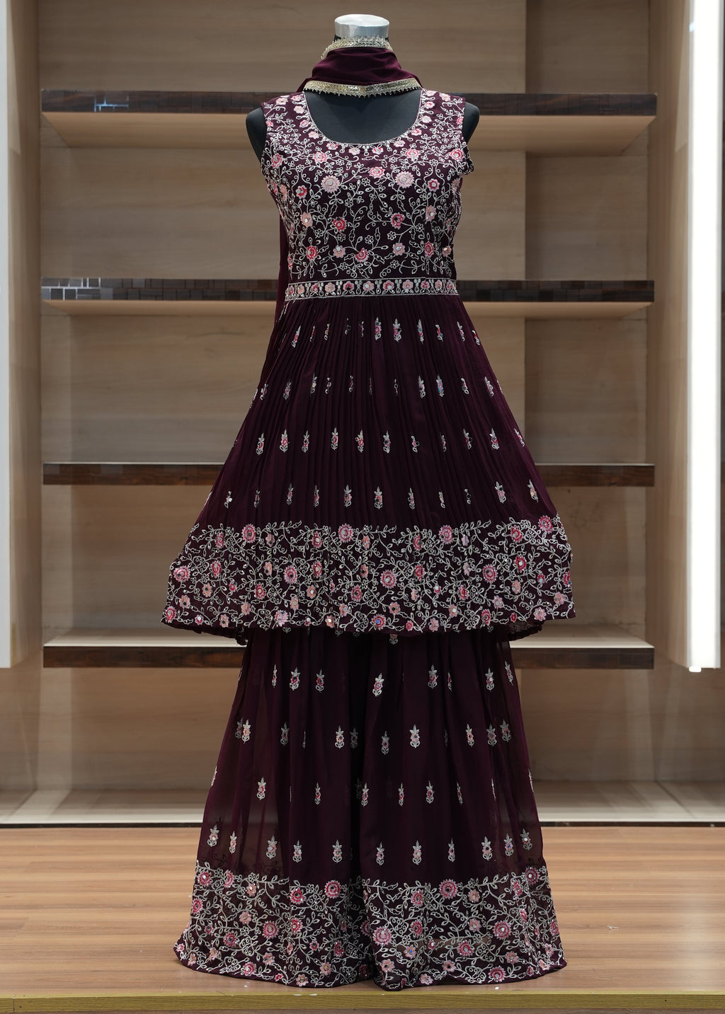 Dress with floral pattern on a mannequin against a wooden background