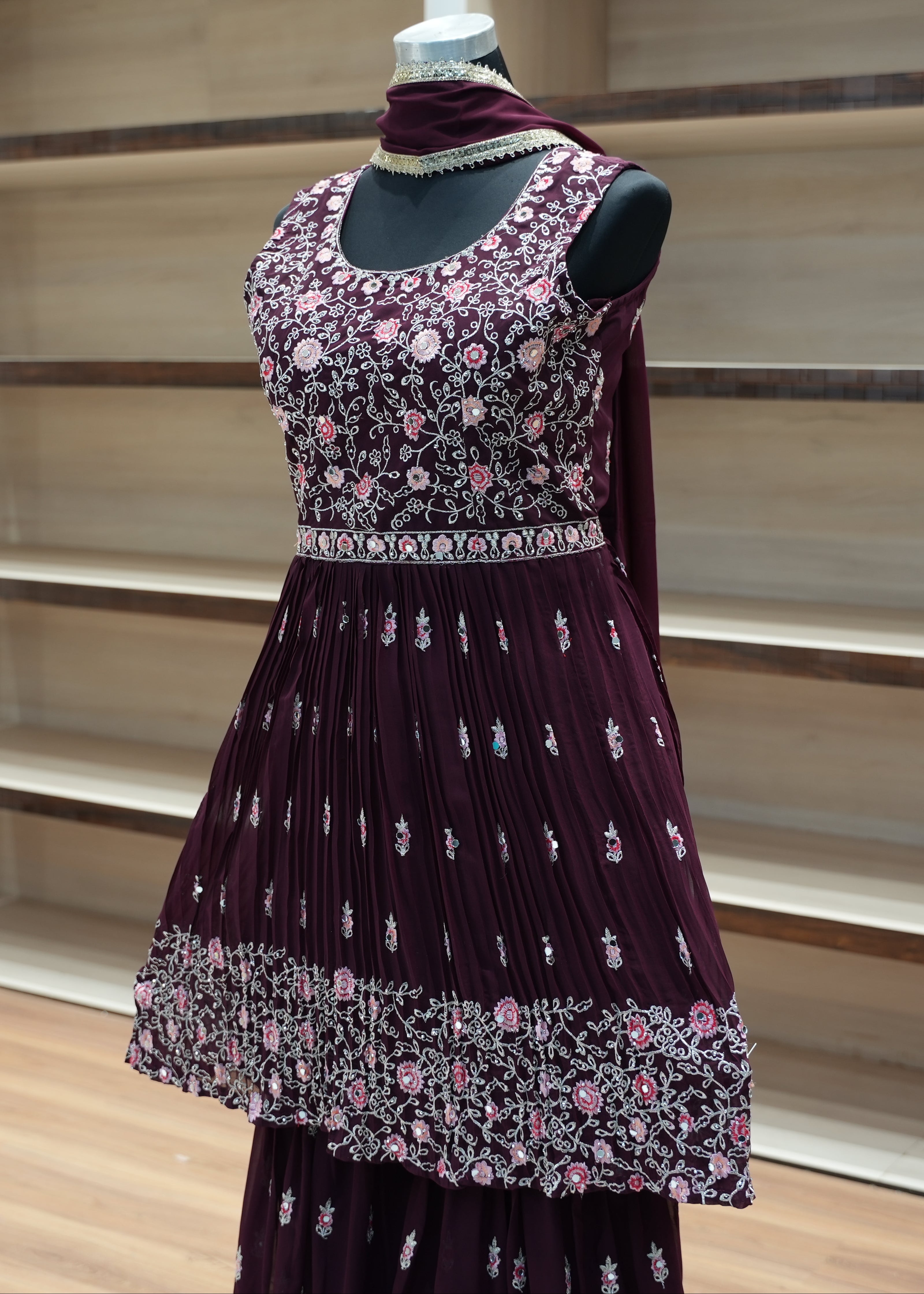 Traditional outfit with floral top and dark purple skirt on a mannequin against a neutral background.