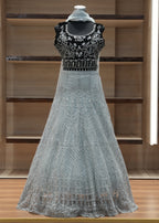 Silver evening gown with intricate detailing on a wooden shelf