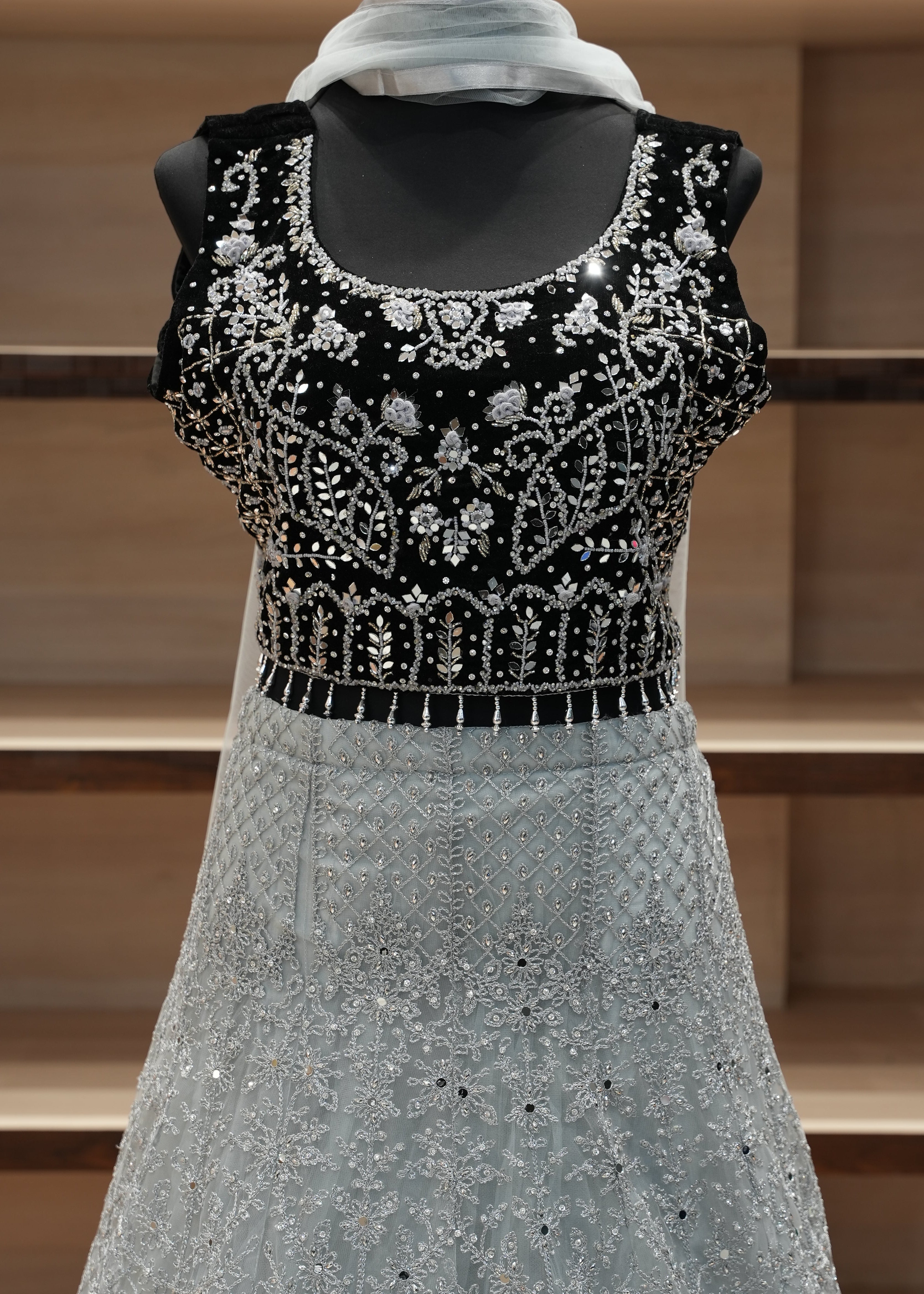 Gray sleeve with black and white beaded cuff against a wooden background