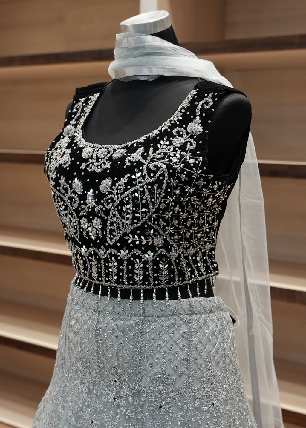 Decorative glove with black and silver beading on a neutral background