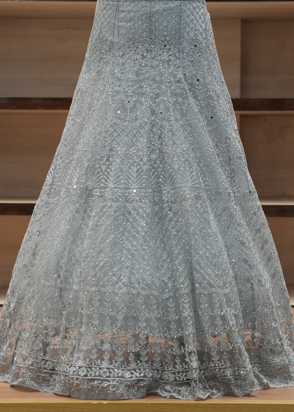 Gray fabric with intricate patterns draped over a wooden surface