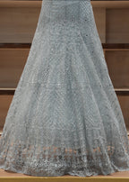 Gray fabric with intricate patterns draped over a wooden surface