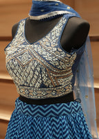 Decorative fabric with intricate patterns on a mannequin against a wooden background